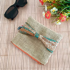 Pochette plate en toile de jute avec un nœud en tissu Wax orange bleu et beige sur le devant