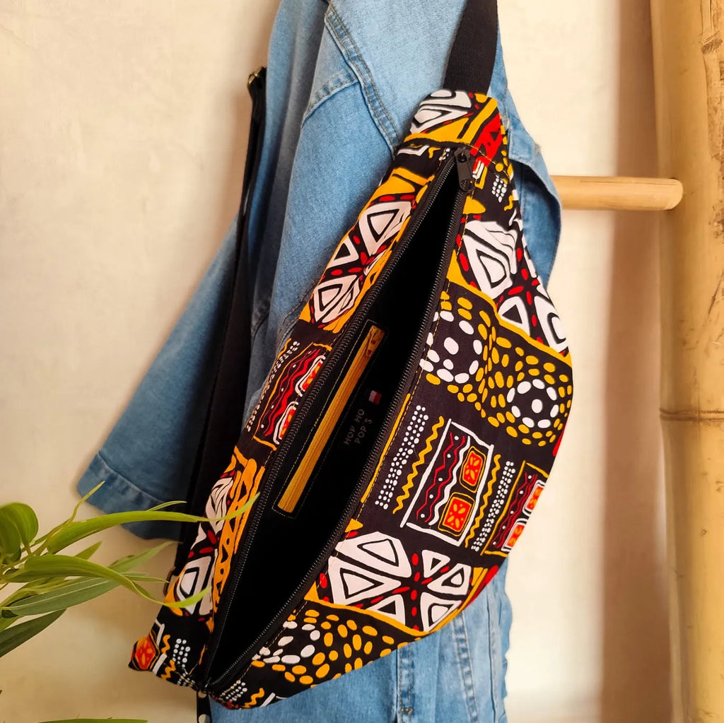 Grand sac banane en tissu Wax motif ethnique noir jaune rouge et blanc ouvert avec intérieur noir et poche zippée