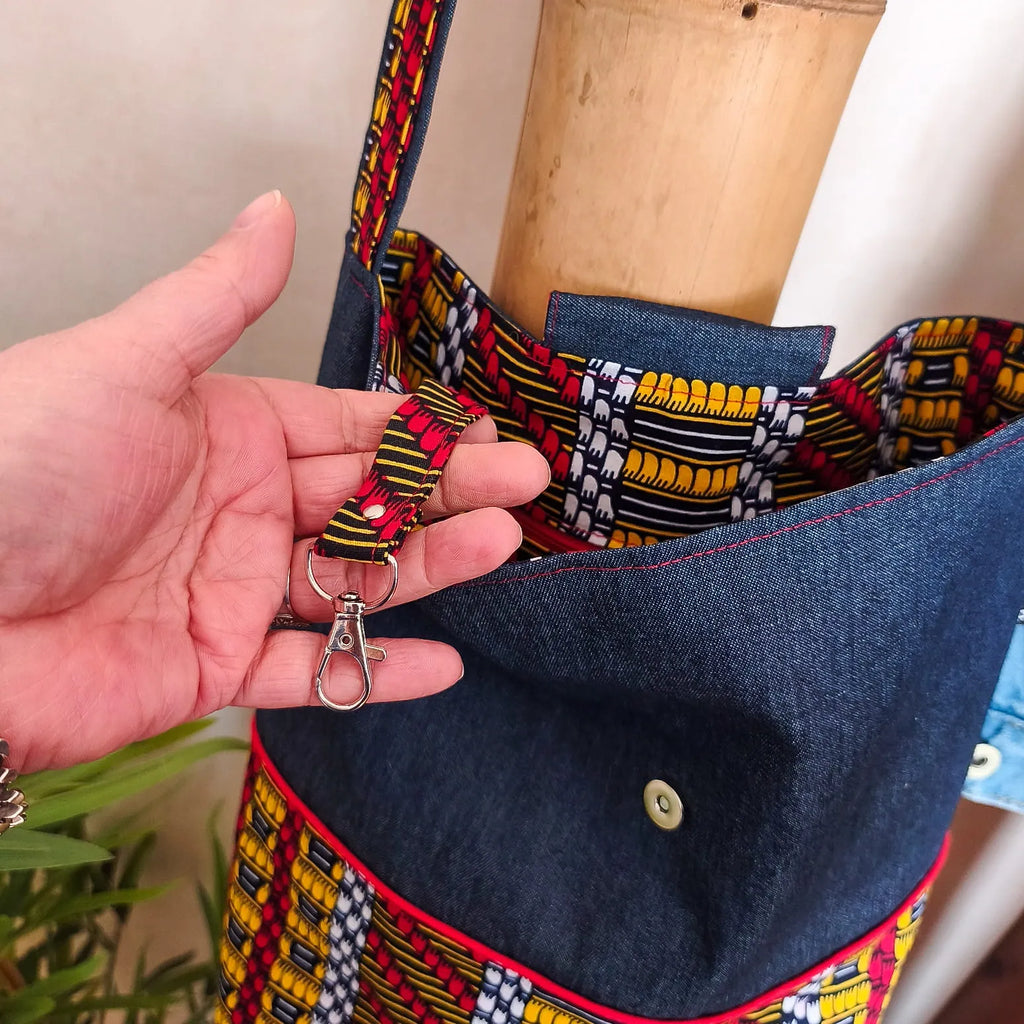 Sac bandoulière en Denim bleu foncé et tissu wax motif ethnique noir jaune rouge et blanc avec attache porte clés à l'intérieur