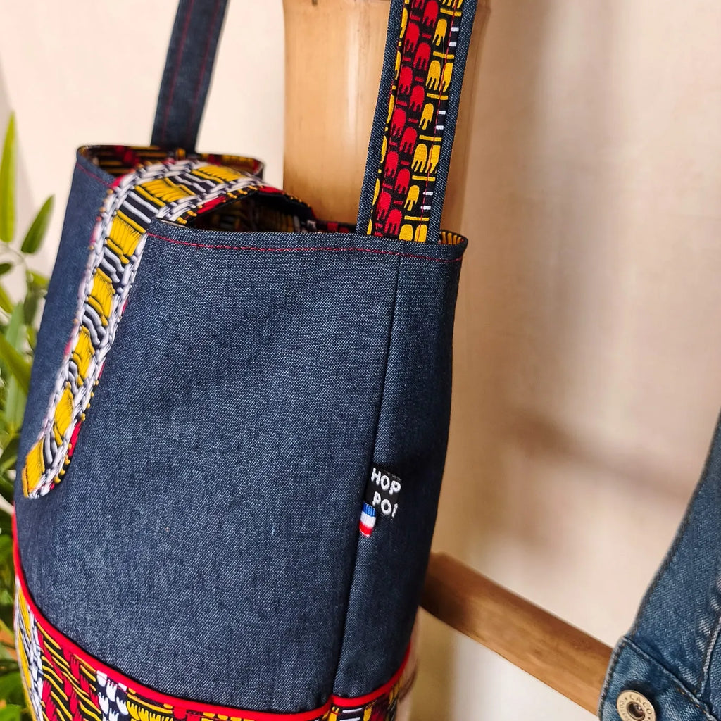 Sac bandoulière en Denim bleu foncé et tissu wax motif ethnique noir jaune rouge et blanc vue du haut du sac