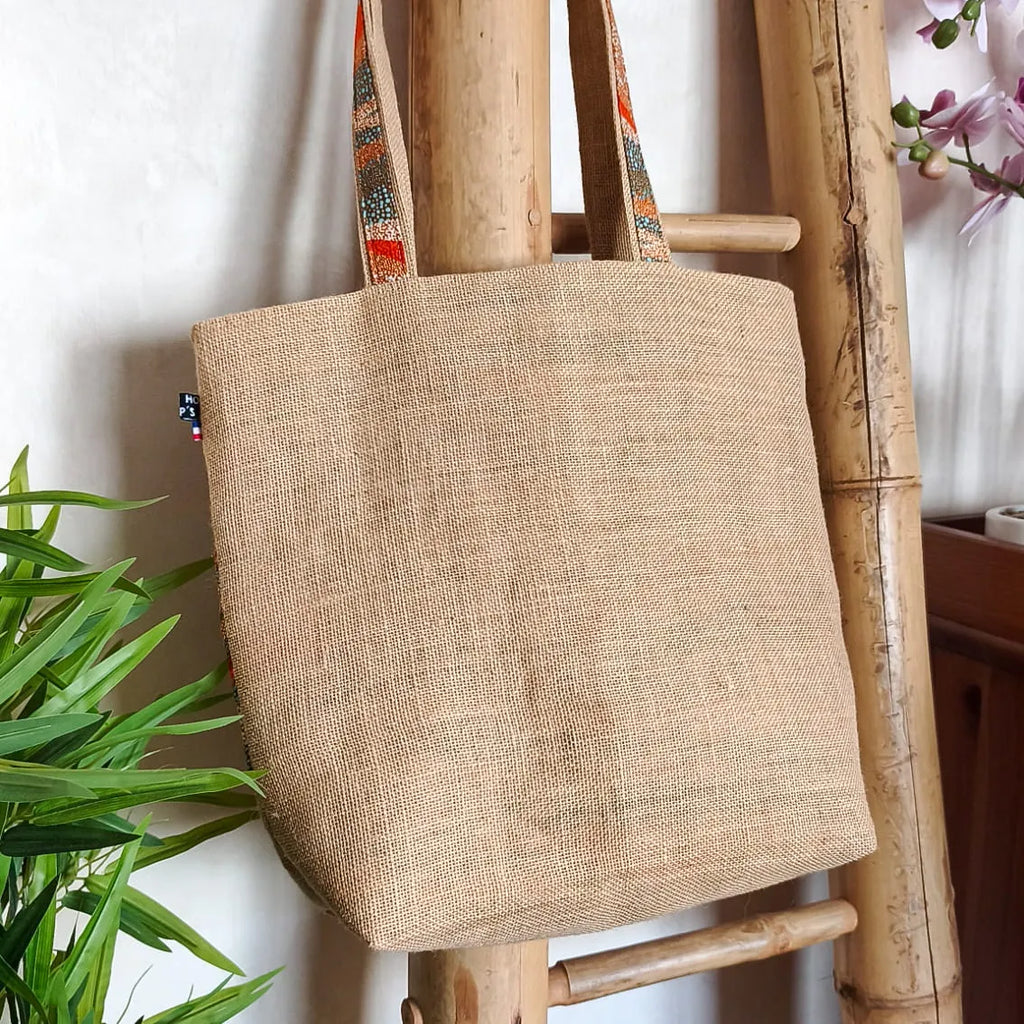Sac cabas en toile de jute avec un gros nœud en tissu wax vu de derrière