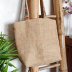 Sac cabas en toile de jute avec un gros nœud en tissu wax vu de derrière